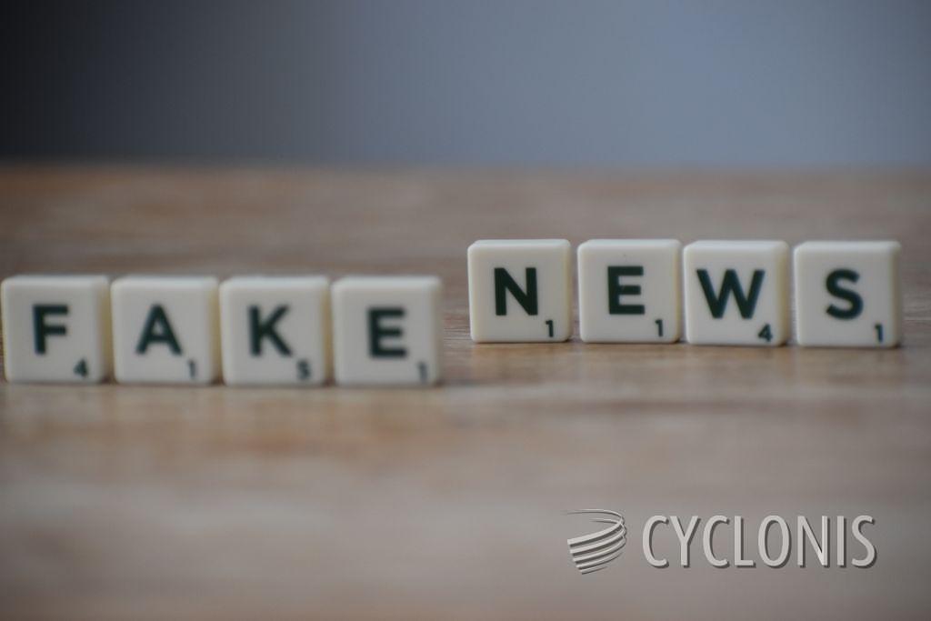 Scrabble tiles spelling 'Fake News' on a wooden surface highlighting misinformation.